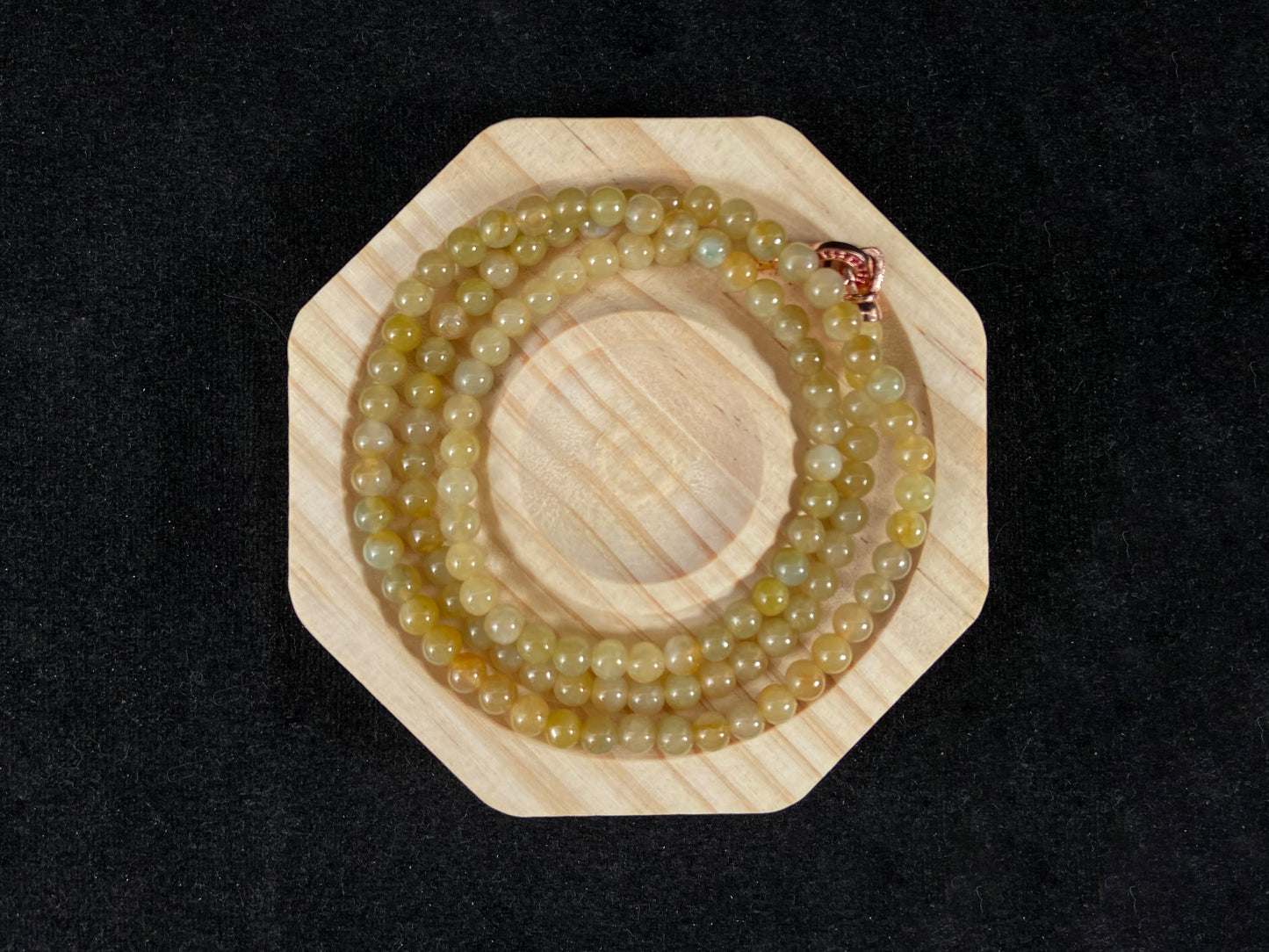 A semi transparent yellow jade bead strand connected by alloy end caps.