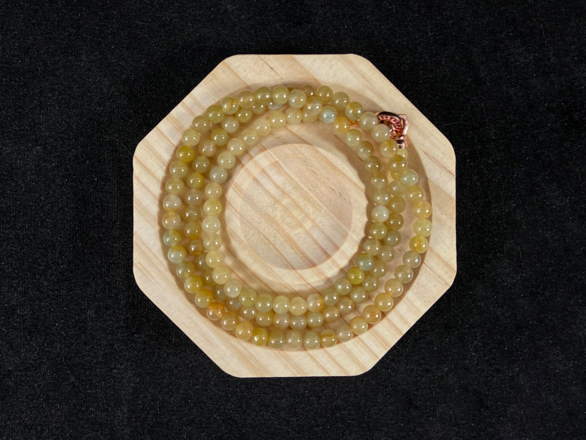 A semi transparent yellow jade bead strand connected by alloy end caps.