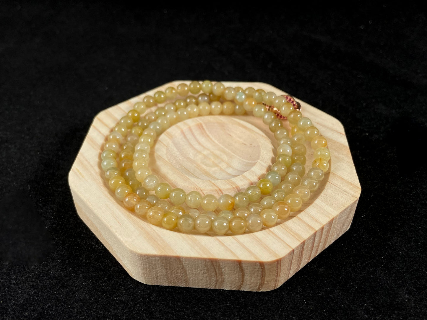 A semi transparent yellow jade bead strand connected by alloy end caps.