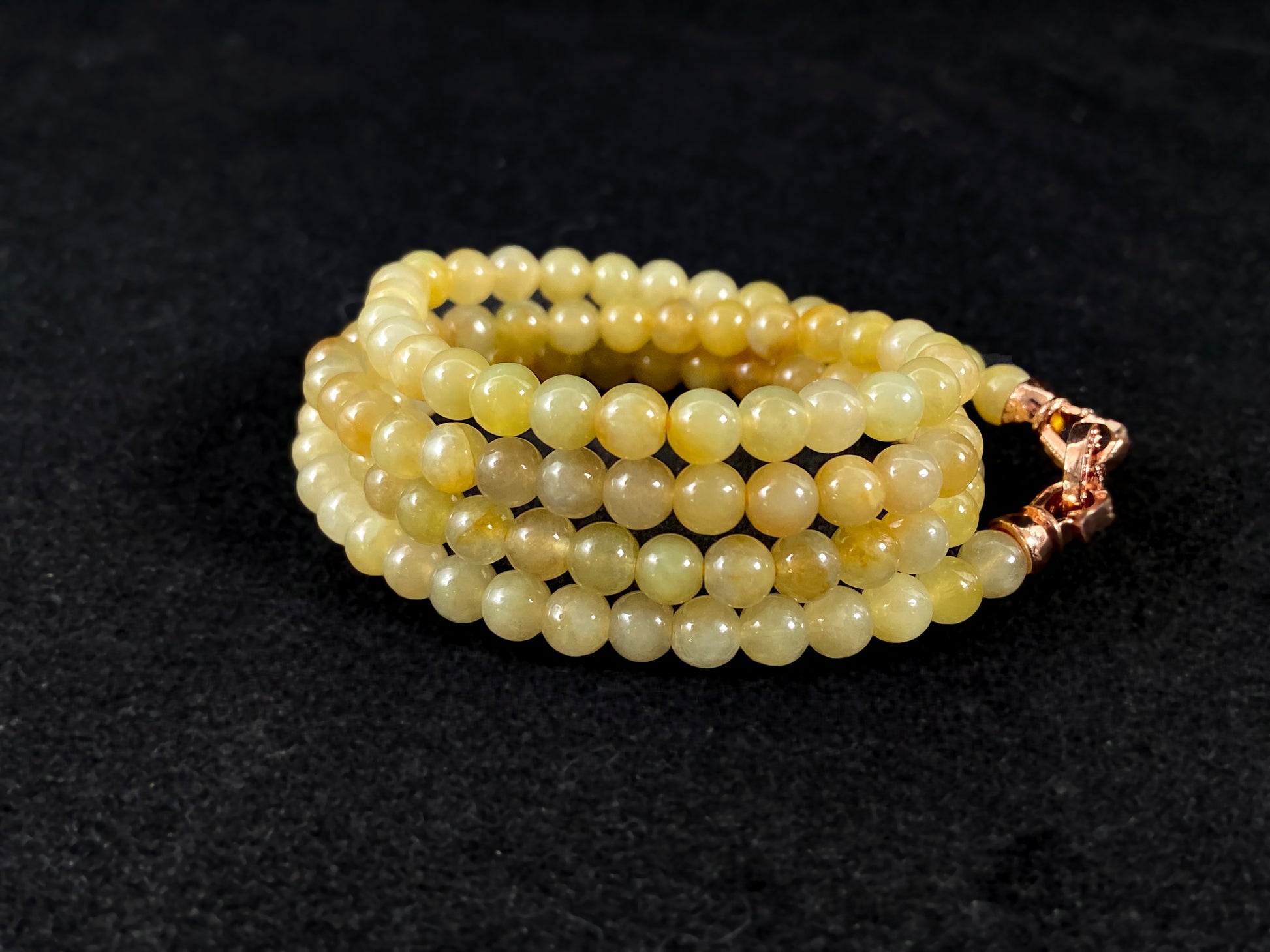 A semi transparent yellow jade bead strand connected by alloy end caps.