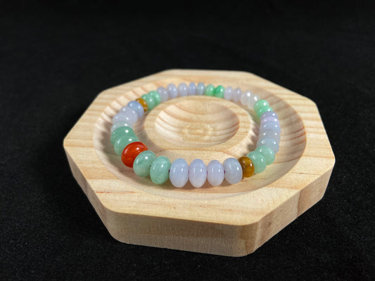 A jade bead strand with graduated sizing from the center, featuring white, green, brown, and red hues.