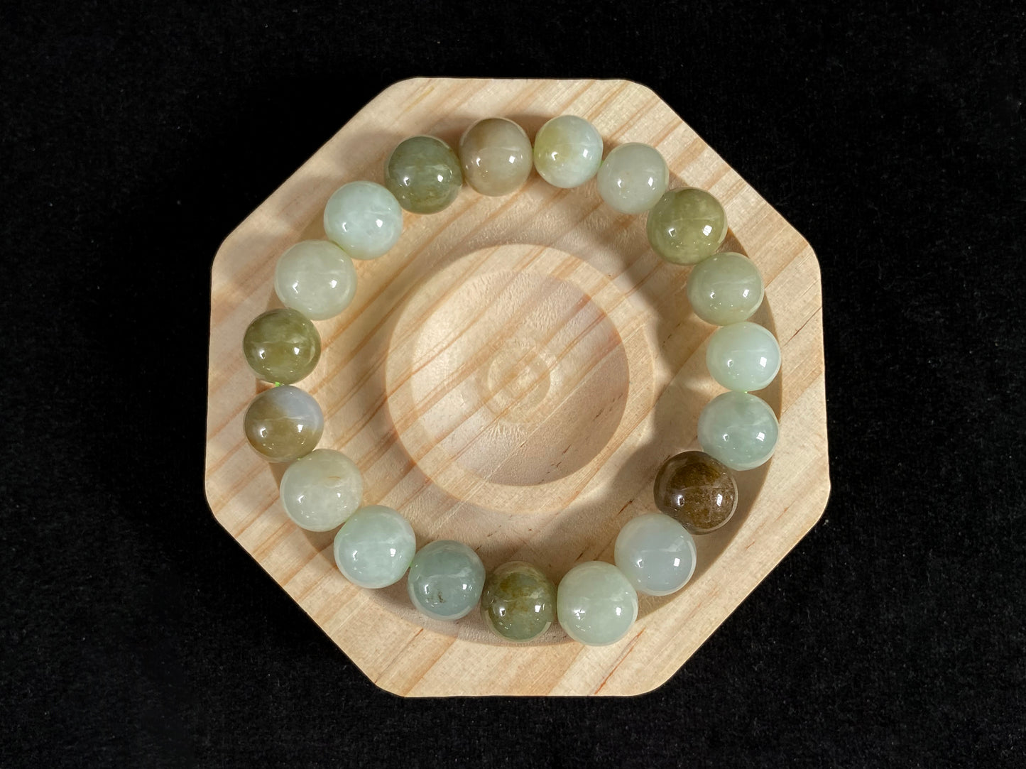 This jade bead strand features a palette of earthy browns, mossy greens, and creamy white.
