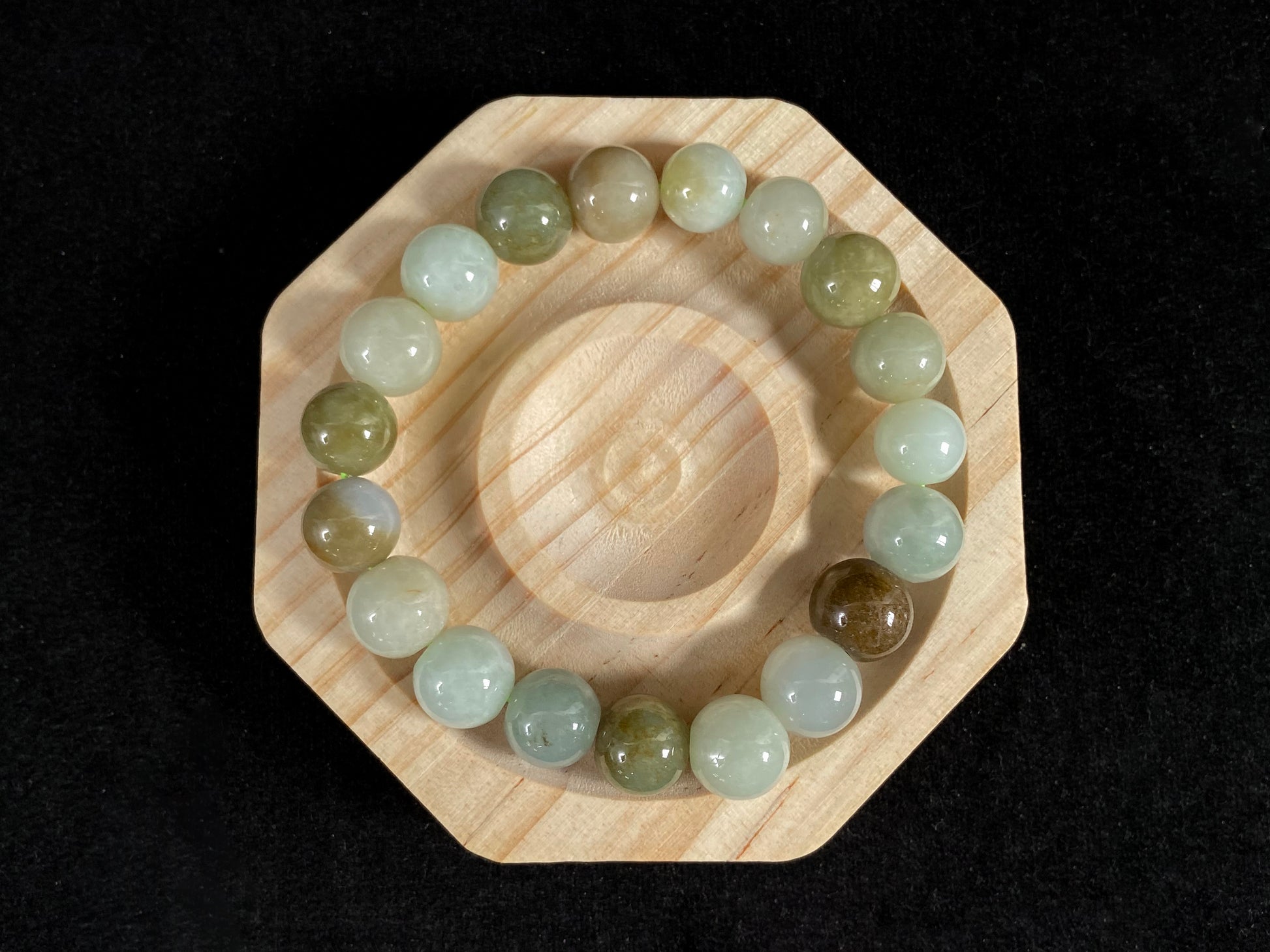 This jade bead strand features a palette of earthy browns, mossy greens, and creamy white.
