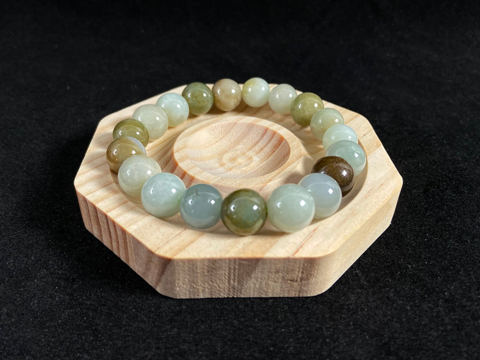 This jade bead strand features a palette of earthy browns, mossy greens, and creamy white.