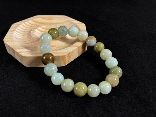 This jade bead strand features a palette of earthy browns, mossy greens, and creamy white.