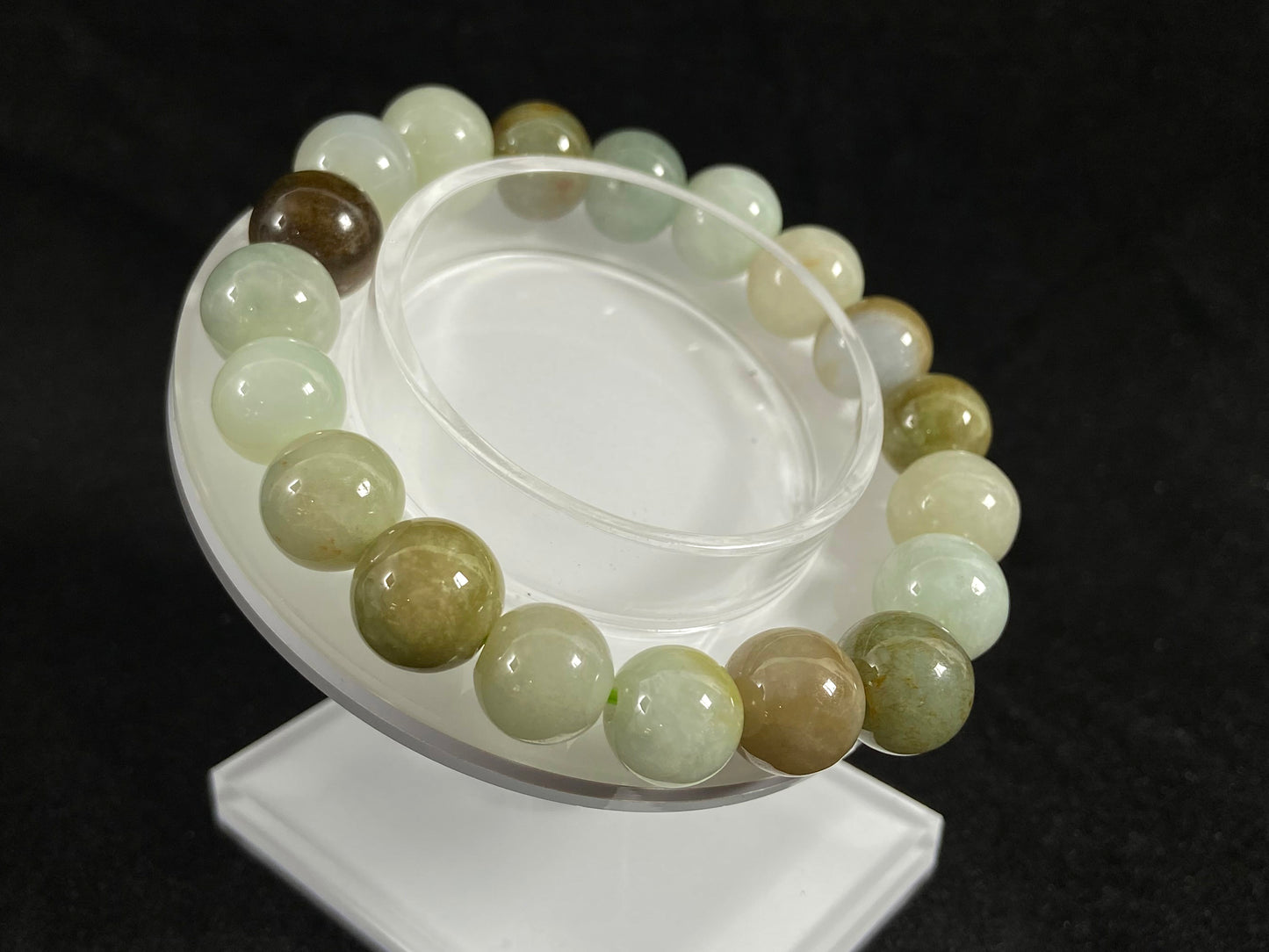 This jade bead strand features a palette of earthy browns, mossy greens, and creamy white.