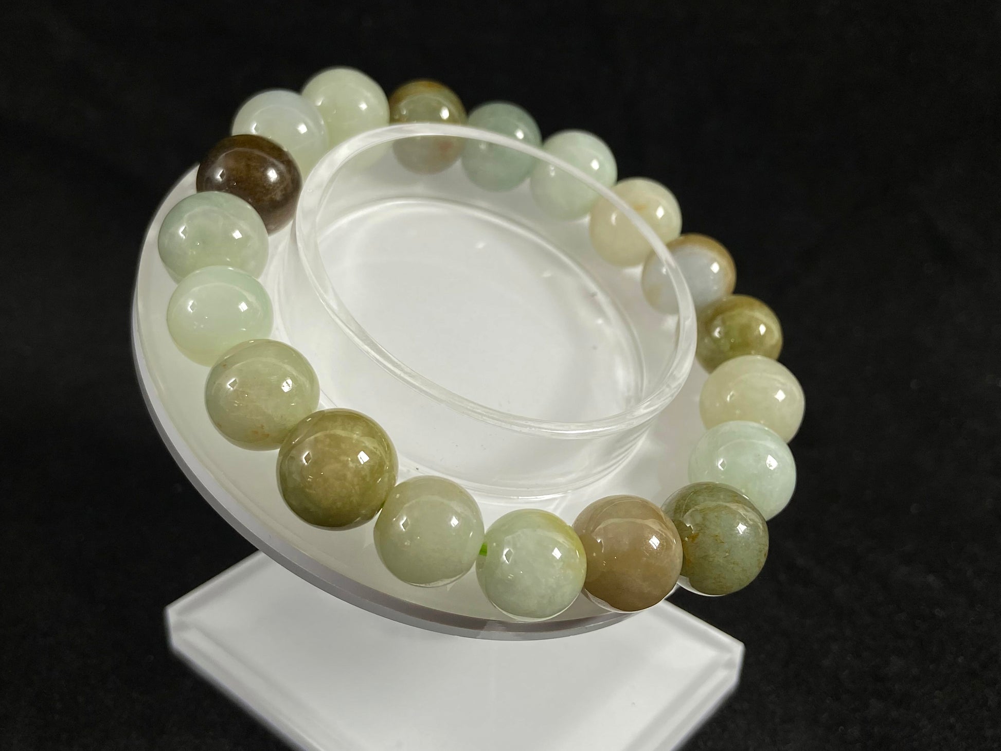 This jade bead strand features a palette of earthy browns, mossy greens, and creamy white.
