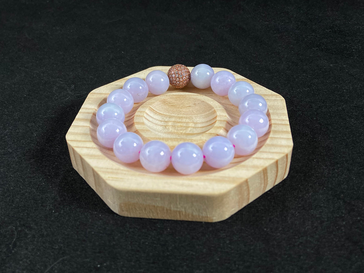 A lavender jade bead strand featuring a silver master bead encased in a gold web pattern.