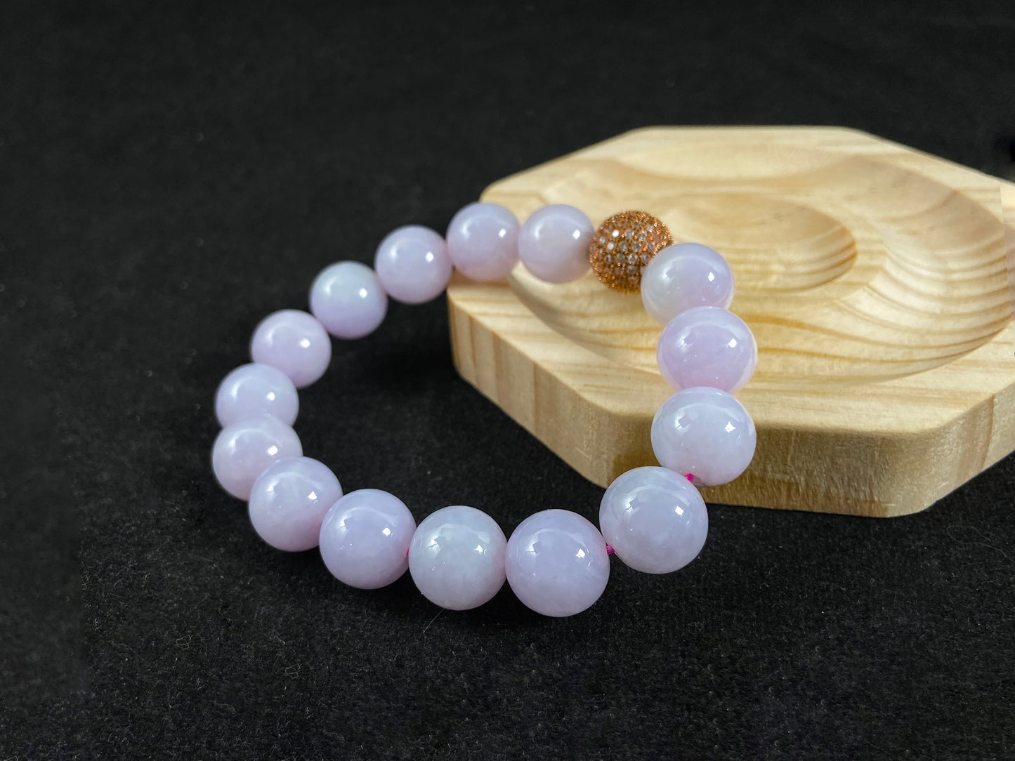 A lavender jade bead strand featuring a silver master bead encased in a gold web pattern.