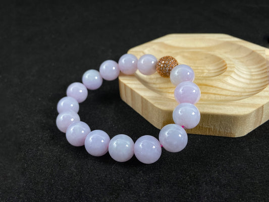 A lavender jade bead strand featuring a silver master bead encased in a gold web pattern.