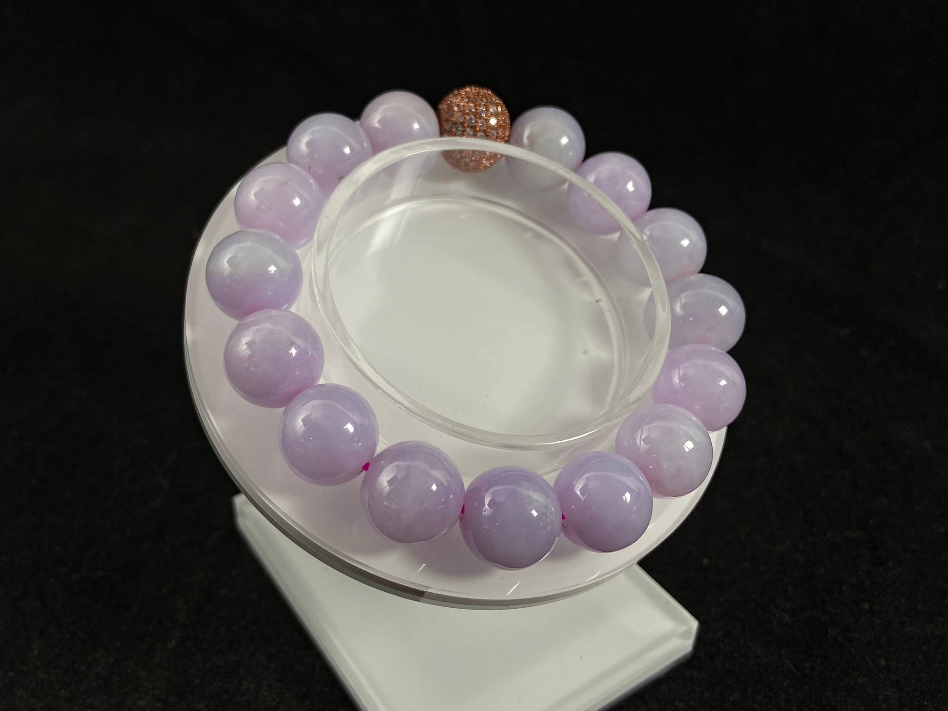 A lavender jade bead strand featuring a silver master bead encased in a gold web pattern.