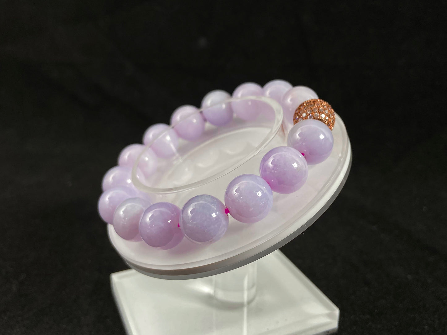 A lavender jade bead strand featuring a silver master bead encased in a gold web pattern.