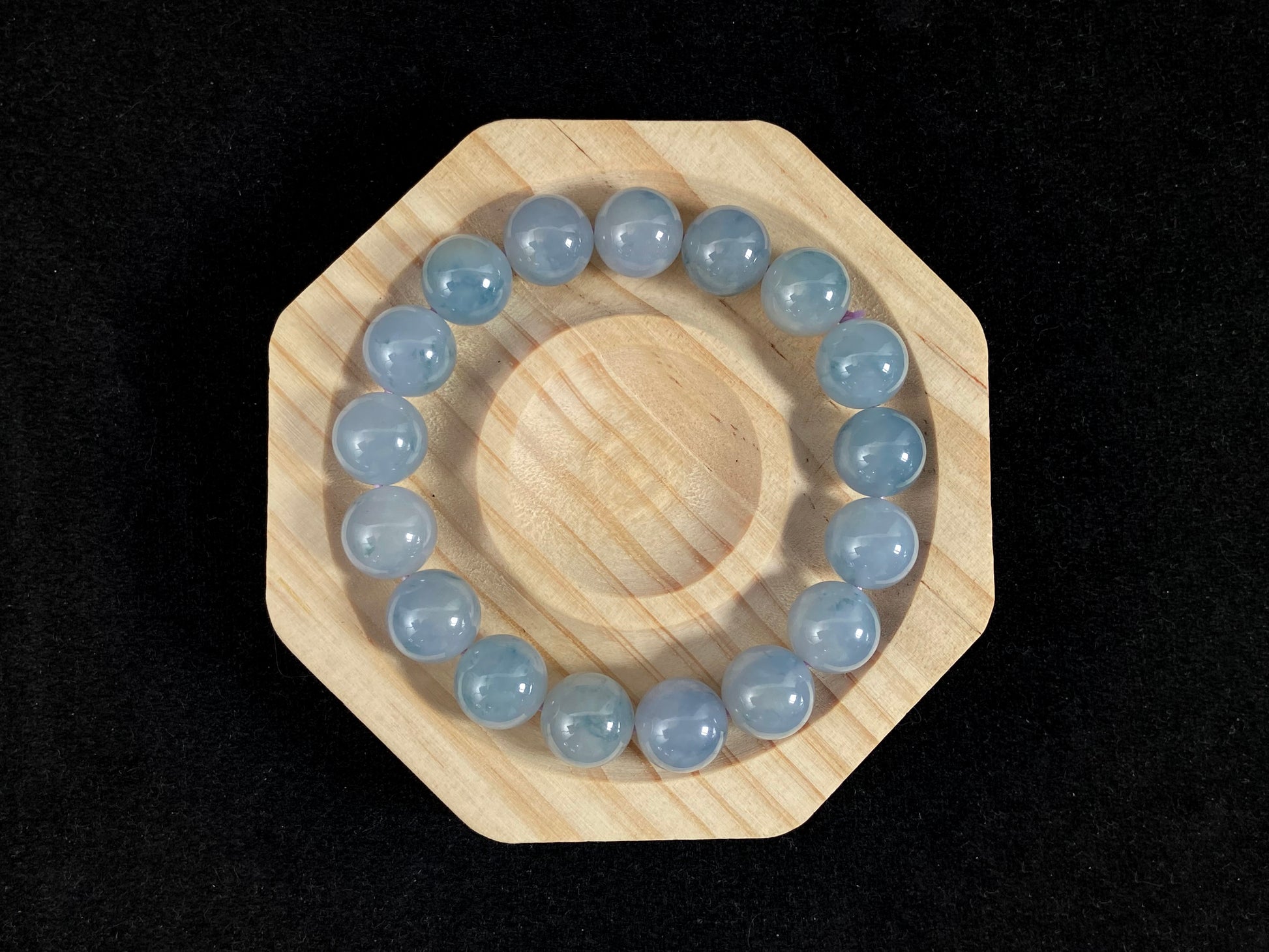 A translucent icy jade bead strand in sky blue tones with floating blue floral inclusions.