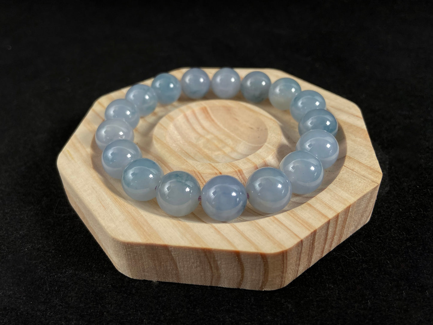 A translucent icy jade bead strand in sky blue tones with floating blue floral inclusions.