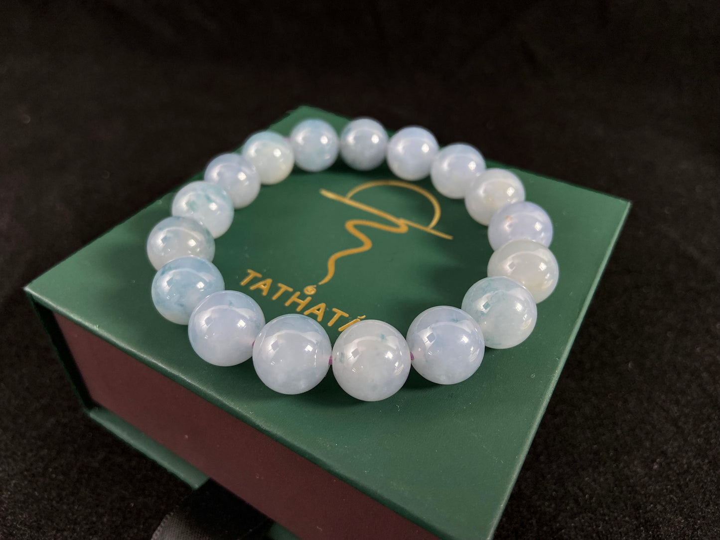 A translucent icy jade bead strand in sky blue tones with floating blue floral inclusions.