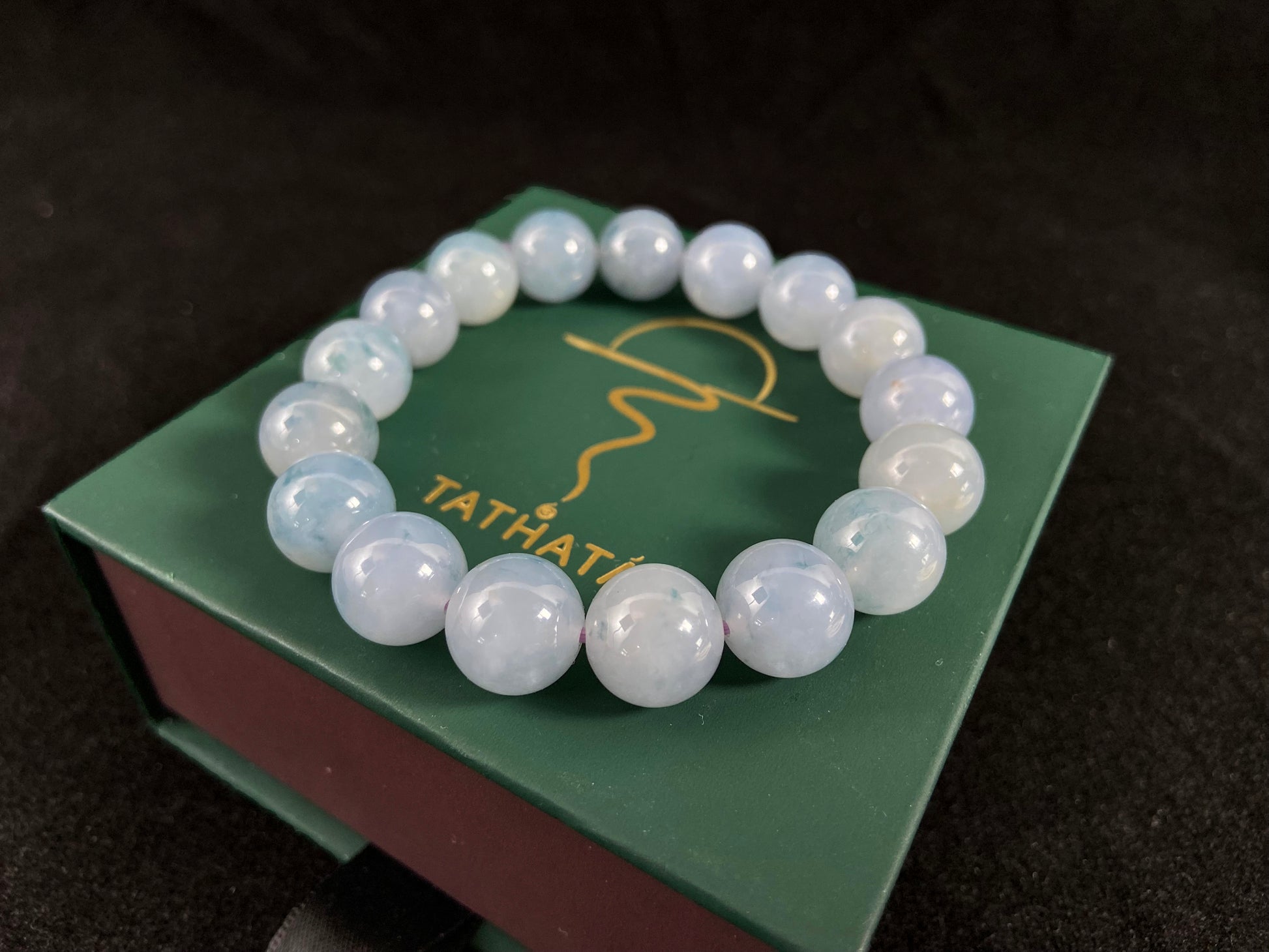 A translucent icy jade bead strand in sky blue tones with floating blue floral inclusions.