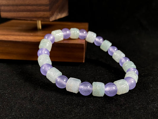 A jade bead strand featuring transparent purple spheres and semi transparent white cylinders.