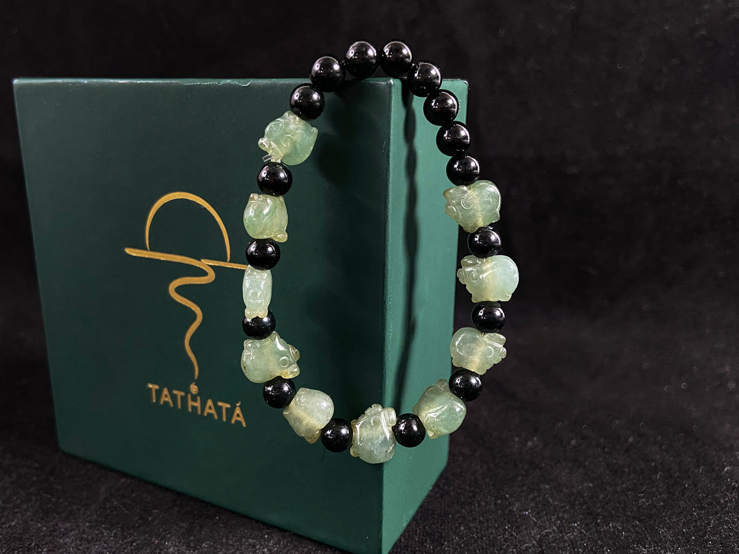 A jade bead strand featuring 17 black beads and 10 light green pig shaped beads.