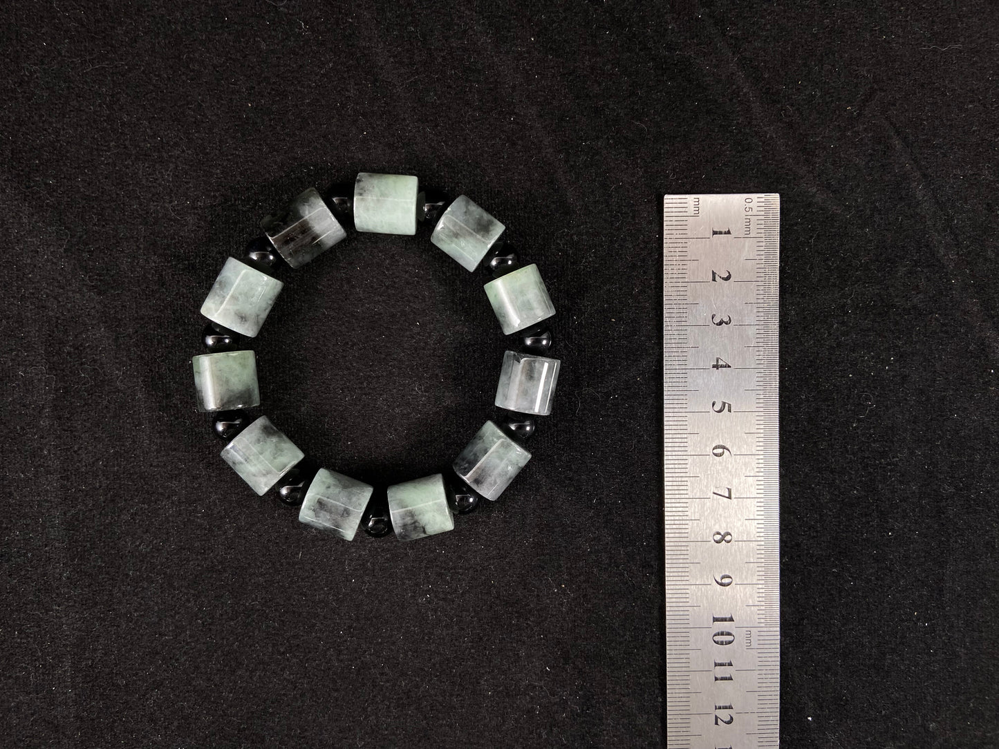 Two black beads combined with a white green black gradient cylinder bead.