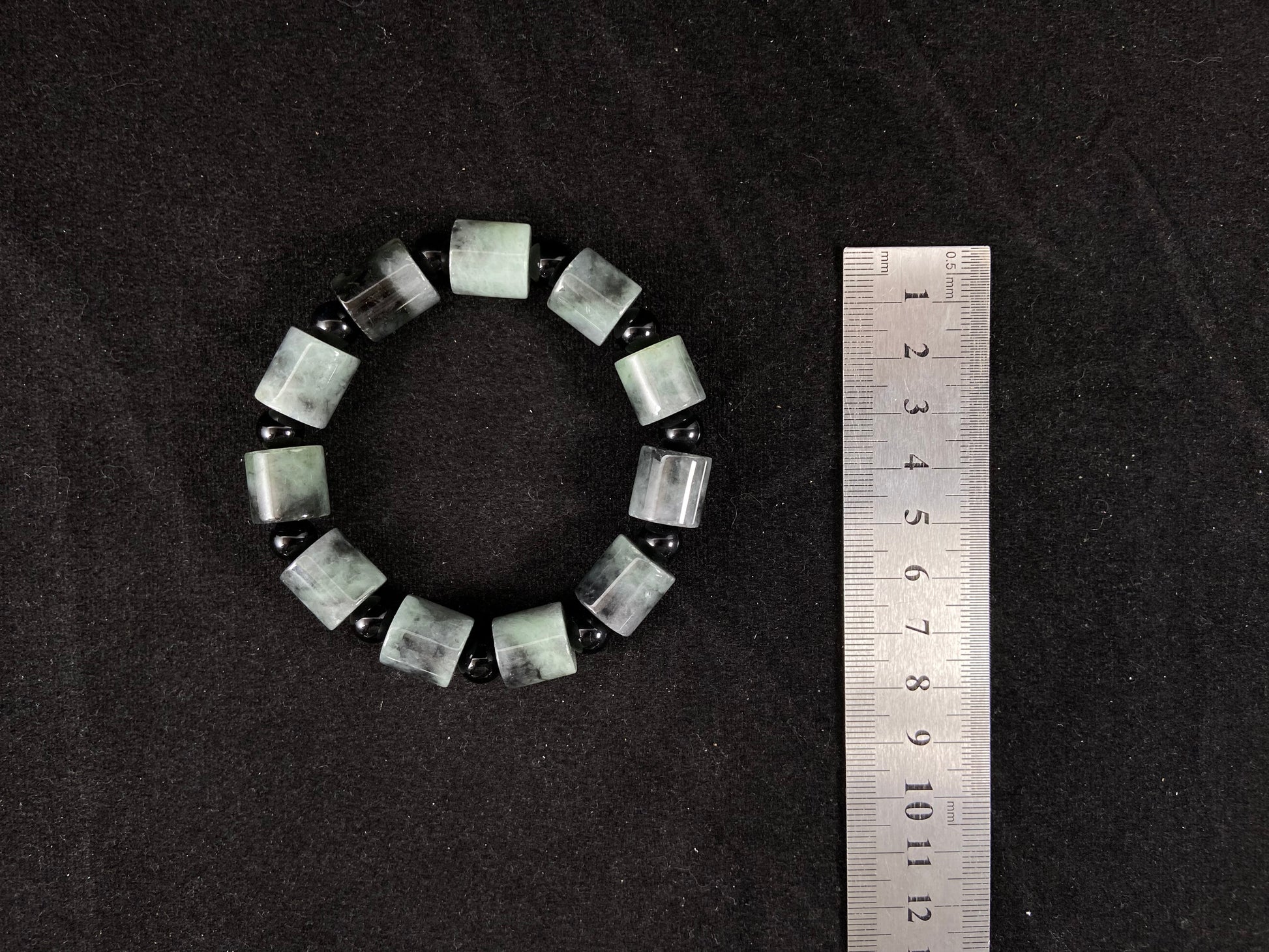 Two black beads combined with a white green black gradient cylinder bead.