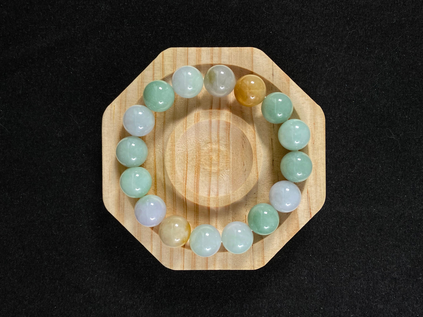 A jade bead strand combining tan, light green, and creamy white tones.