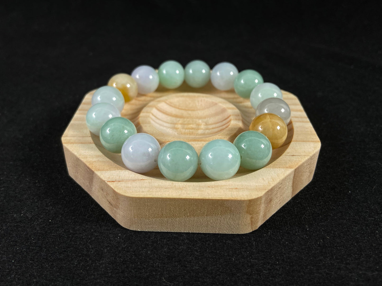 A jade bead strand combining tan, light green, and creamy white tones.