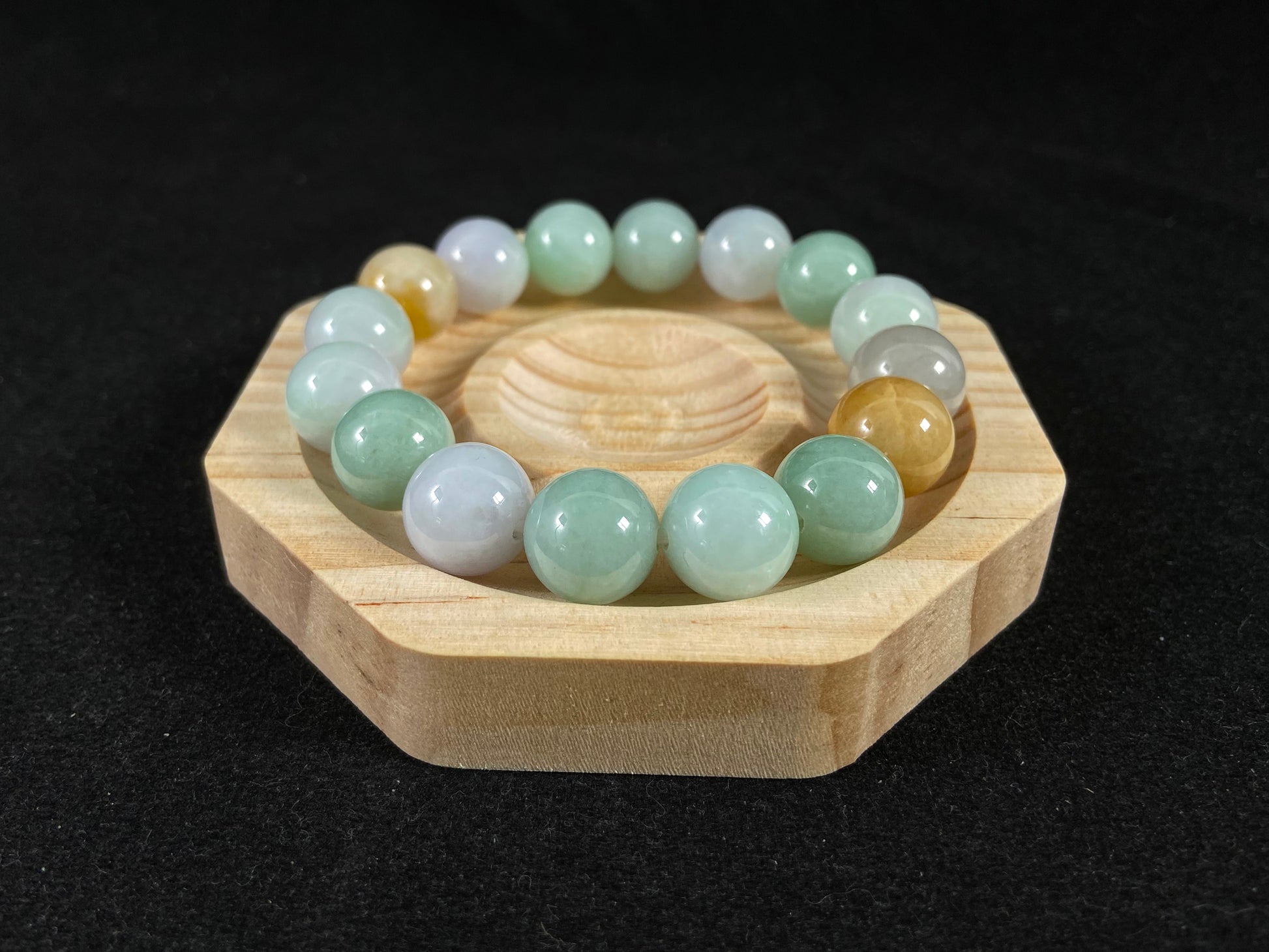 A jade bead strand combining tan, light green, and creamy white tones.