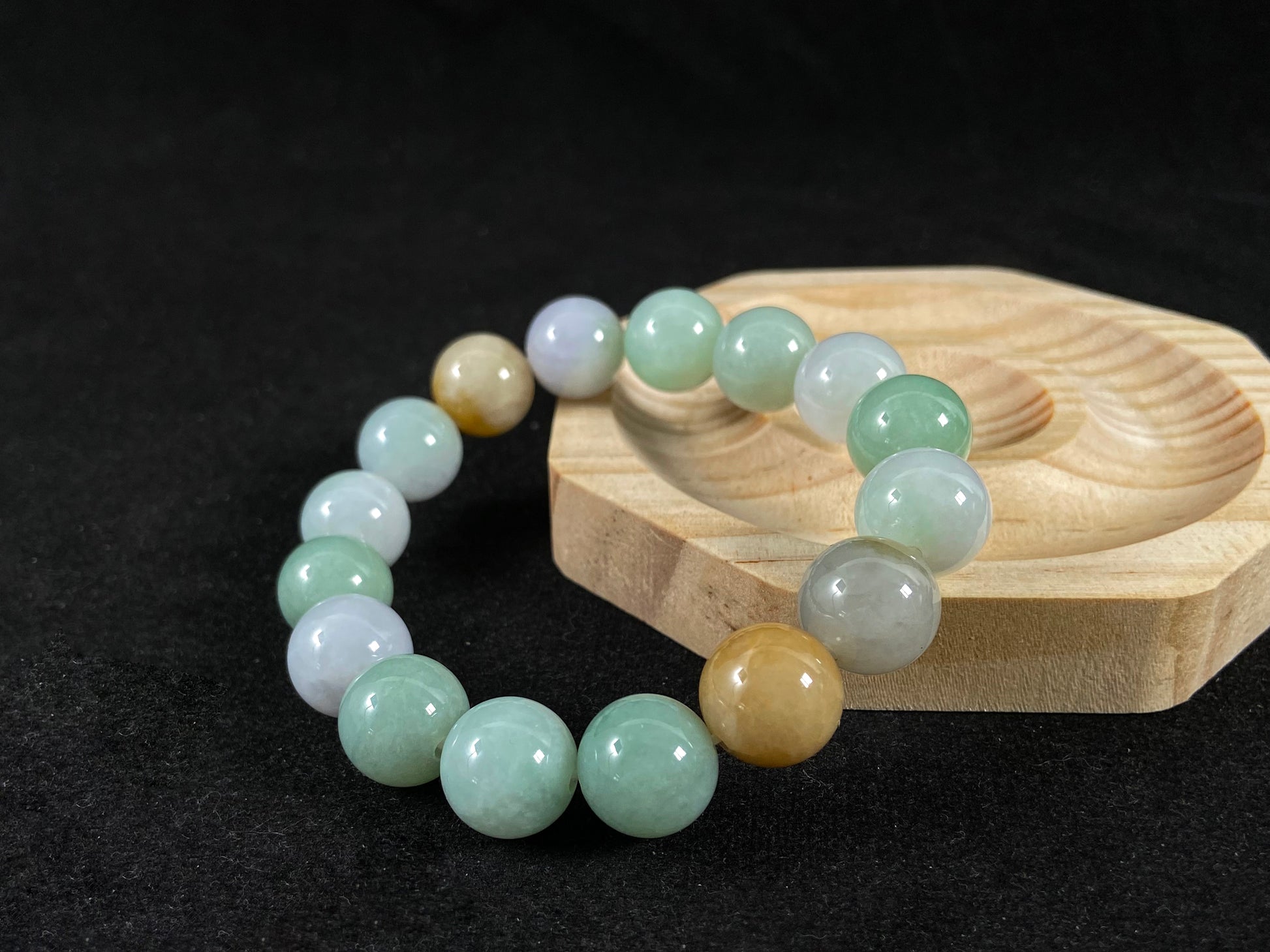 A jade bead strand combining tan, light green, and creamy white tones.