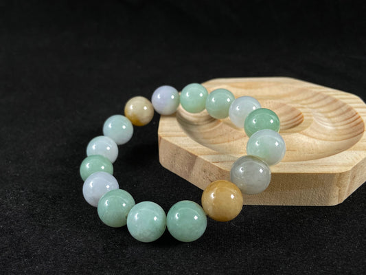 A jade bead strand combining tan, light green, and creamy white tones.