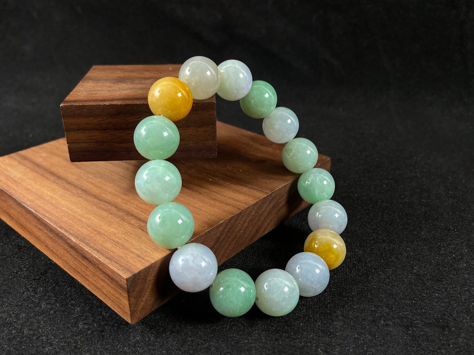 A jade bead strand combining tan, light green, and creamy white tones.