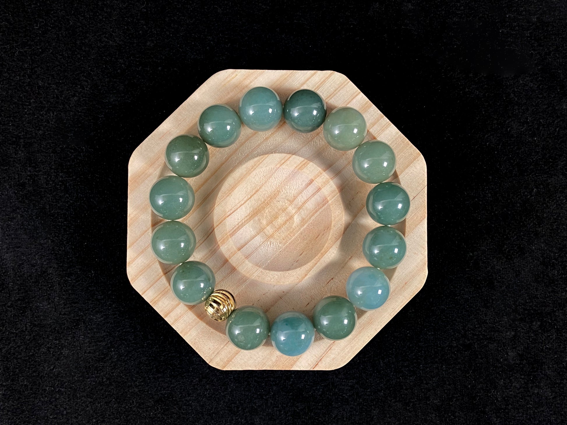 A jade bead strand featuring light blue, deep green, and light green beads with an alloy accent.