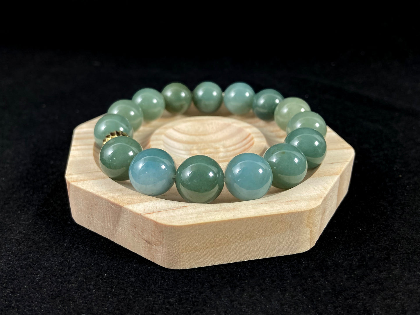 A jade bead strand featuring light blue, deep green, and light green beads with an alloy accent.