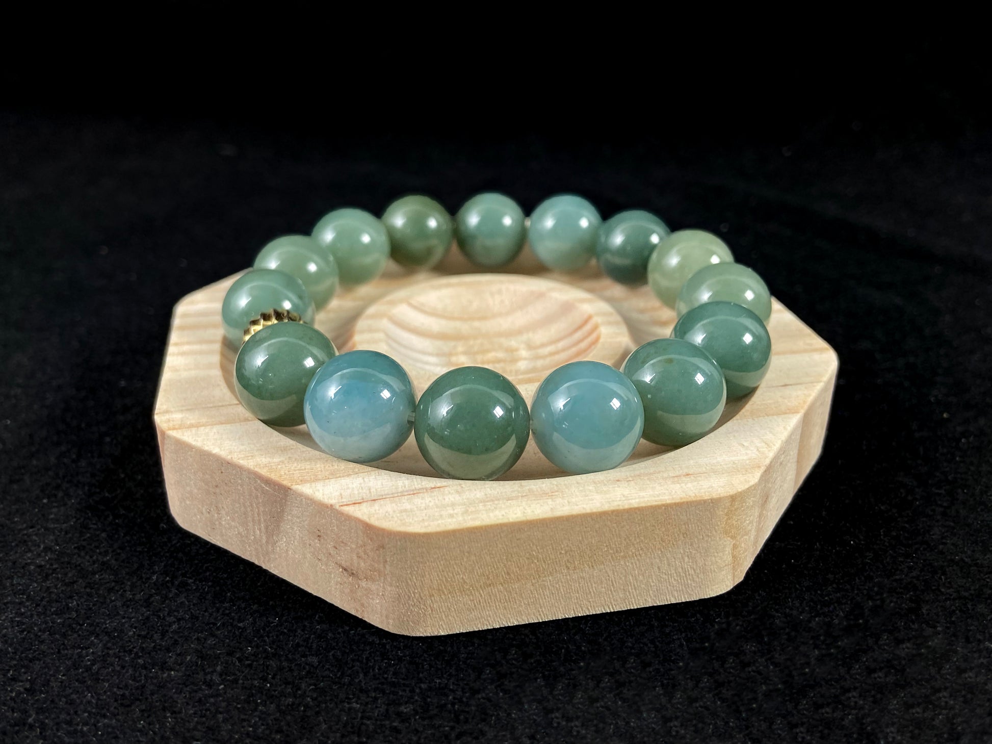 A jade bead strand featuring light blue, deep green, and light green beads with an alloy accent.
