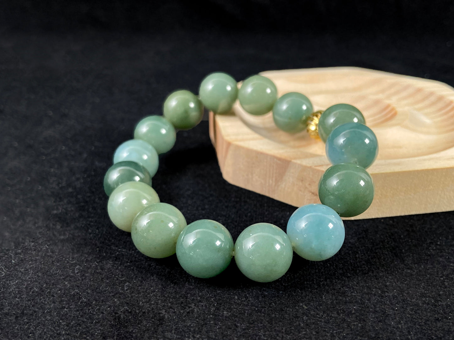 A jade bead strand featuring light blue, deep green, and light green beads with an alloy accent.