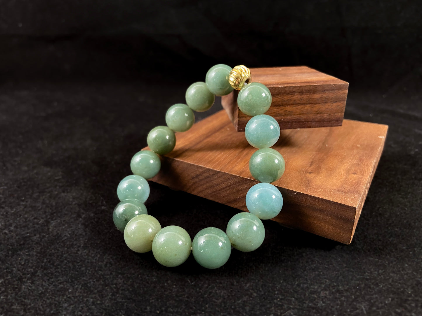 A jade bead strand featuring light blue, deep green, and light green beads with an alloy accent.