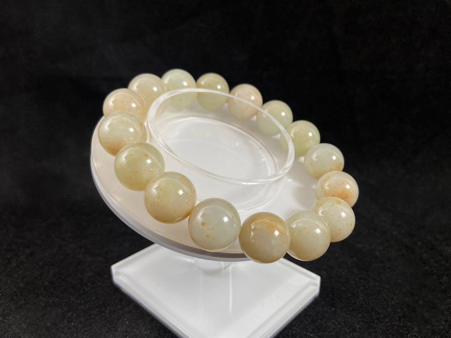 A strand of beige jade beads delicately adorned with golden speckles.