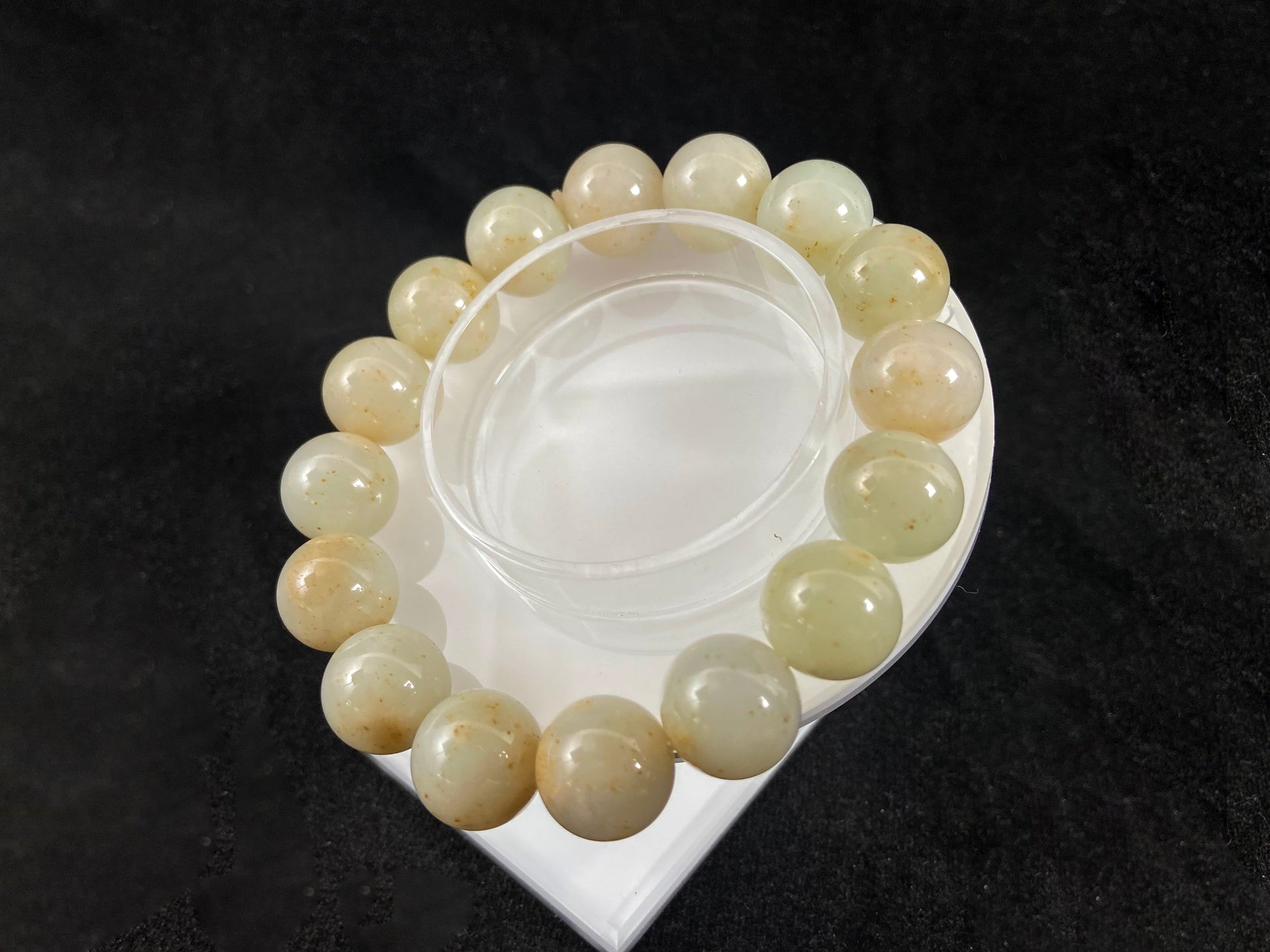 A strand of beige jade beads delicately adorned with golden speckles.