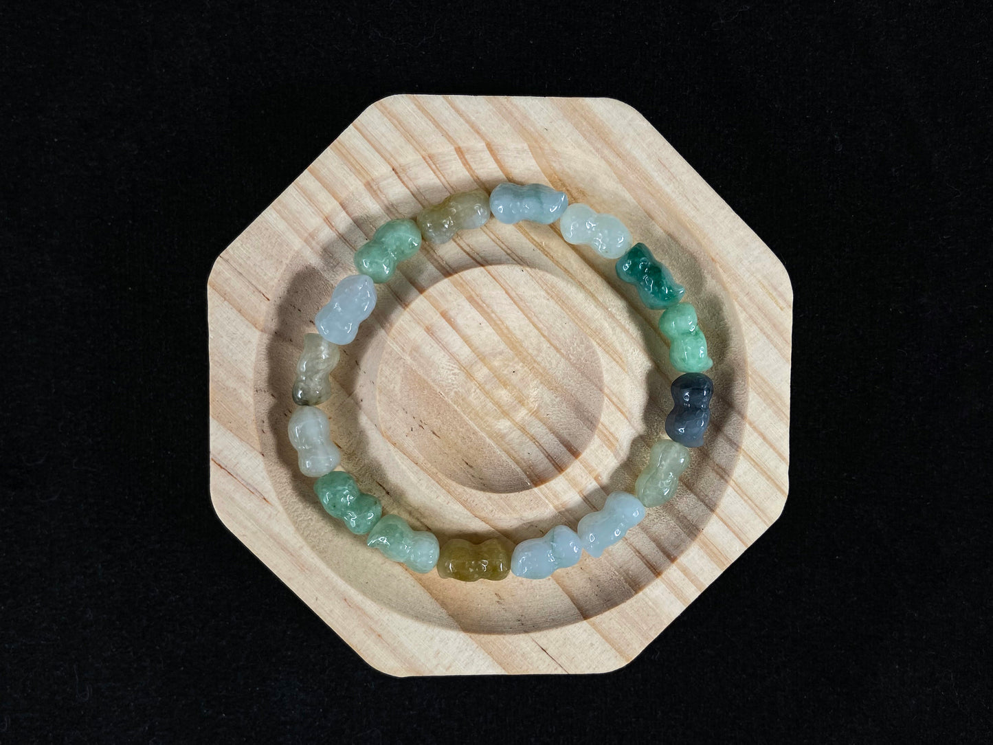 A strand of peanut shaped jade beads in soft yellow, green, brown, grey and ombre white to deep green.