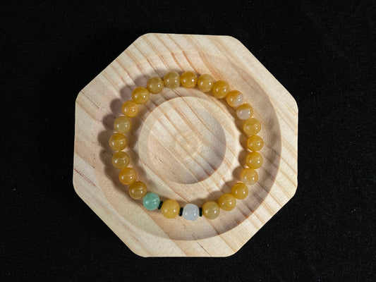 This jade bracelet has mostly yellow beads, plus one apple green and one creamy white bead.