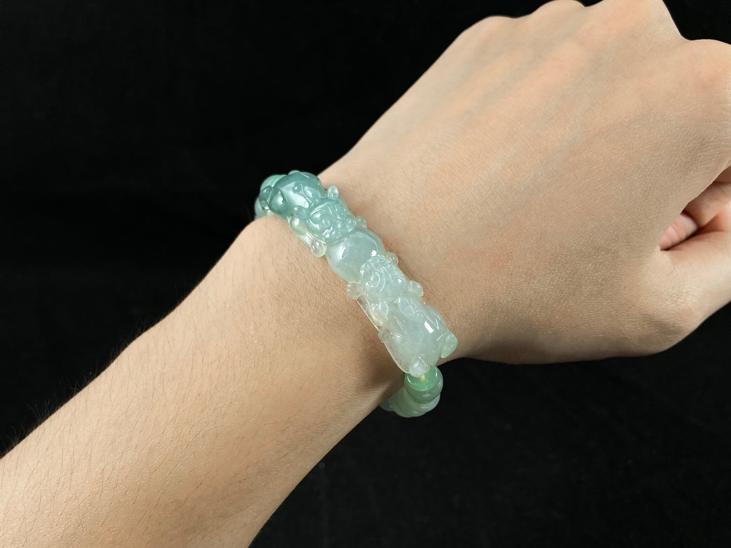 A light green translucent jade bead bracelet featuring two matching Pixiu charms.