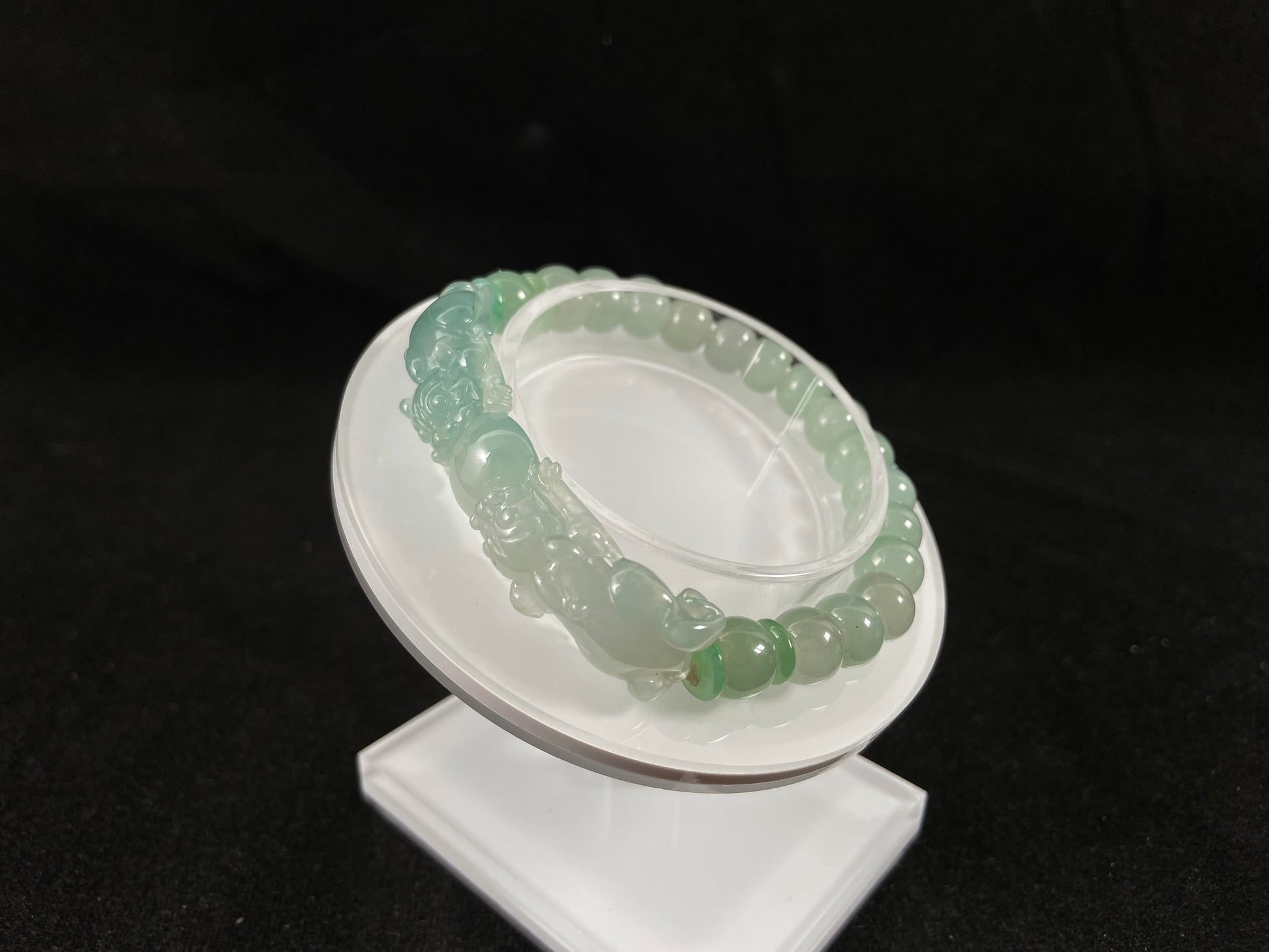 A light green translucent jade bead bracelet featuring two matching Pixiu charms.