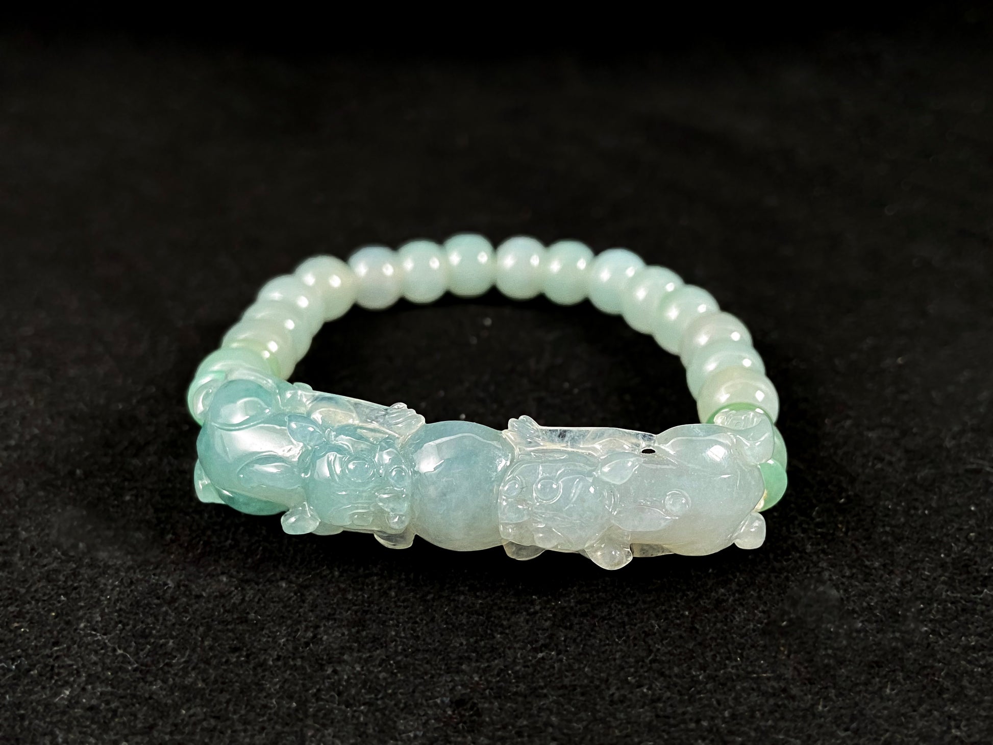 A light green translucent jade bead bracelet featuring two matching Pixiu charms.
