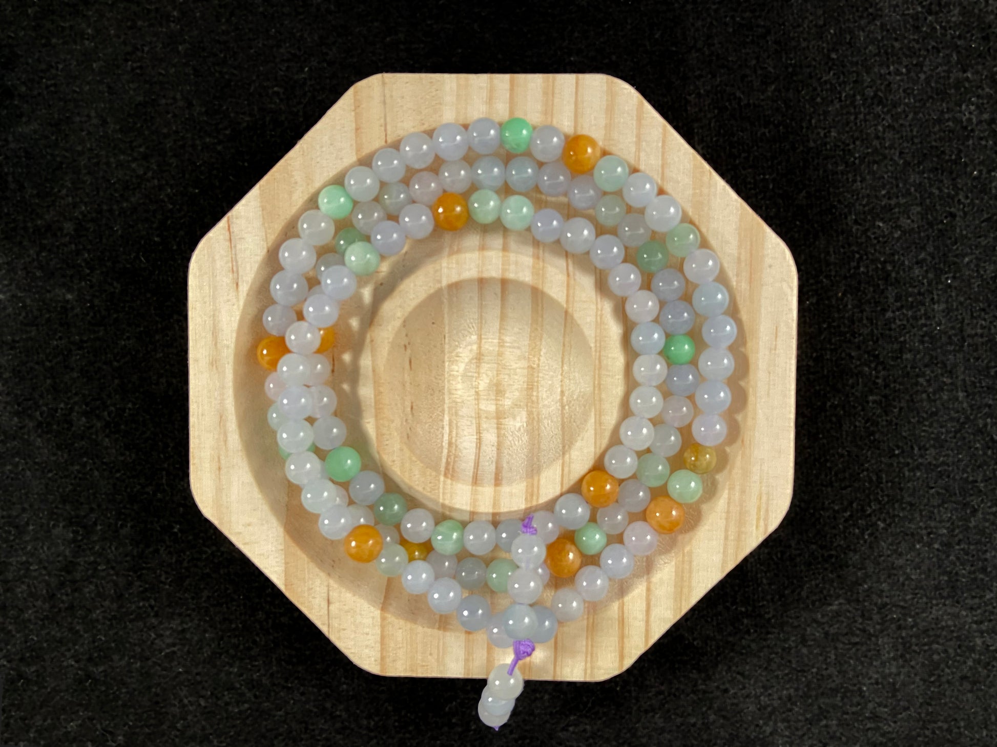 A jade bead strand primarily featuring icy, light green, and golden beads.