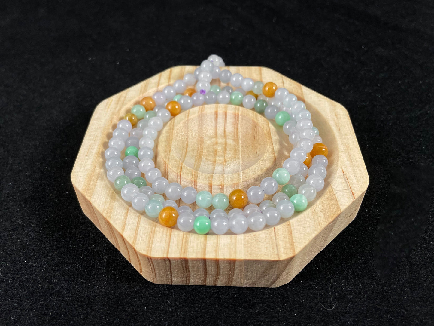 A jade bead strand primarily featuring icy, light green, and golden beads.