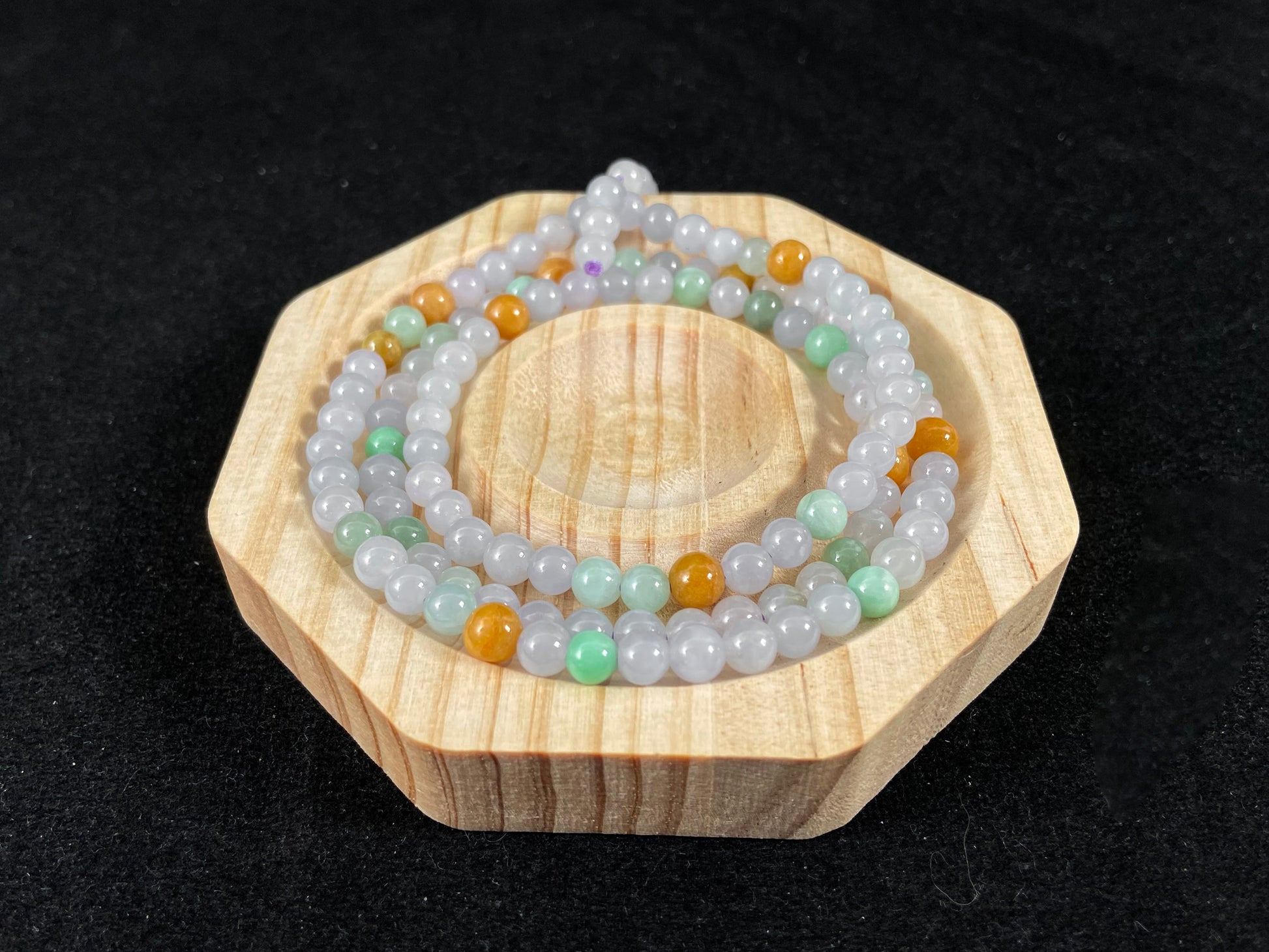 A jade bead strand primarily featuring icy, light green, and golden beads.