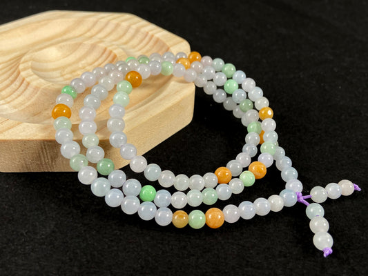 A jade bead strand primarily featuring icy, light green, and golden beads.