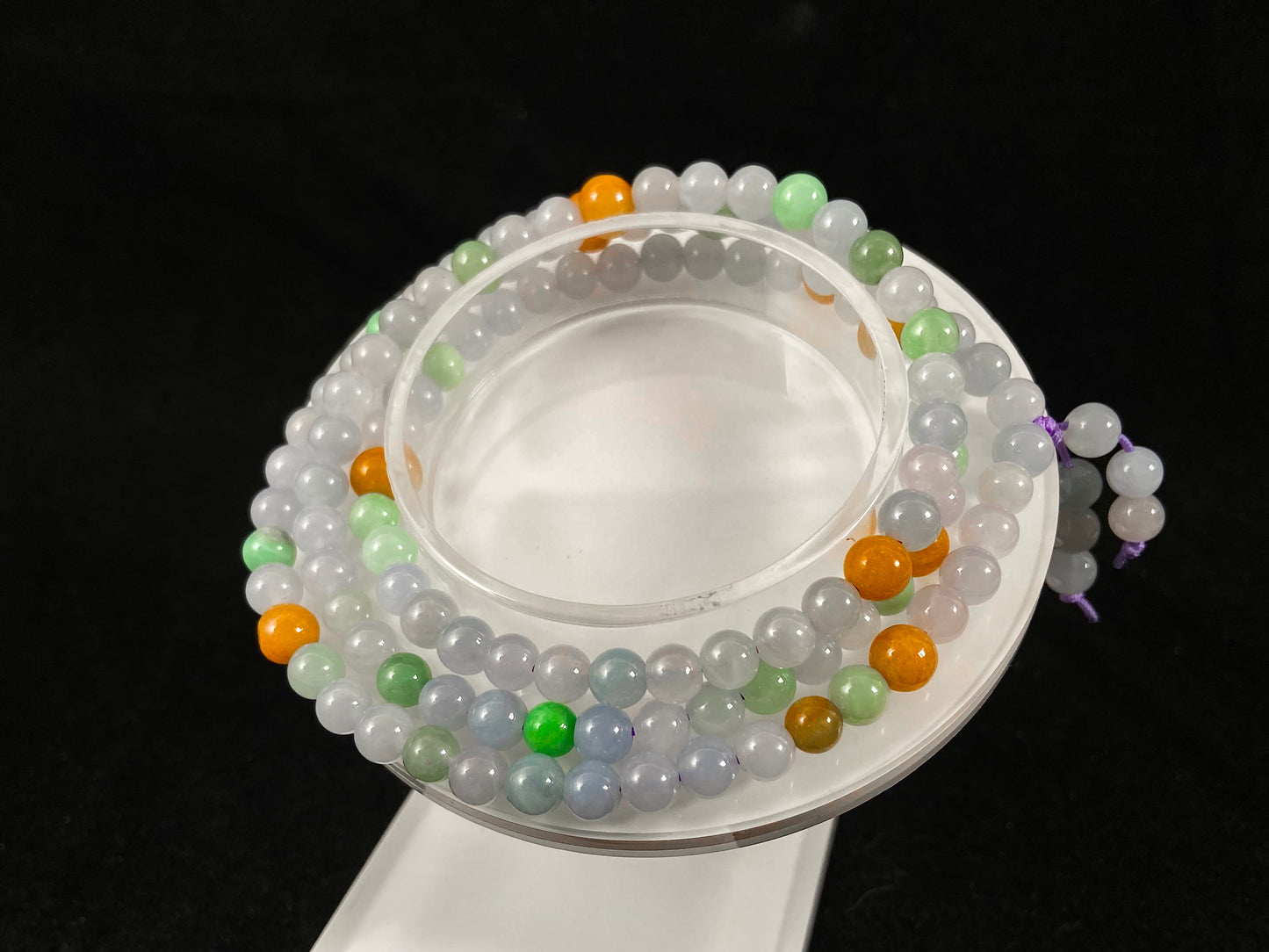 A jade bead strand primarily featuring icy, light green, and golden beads.