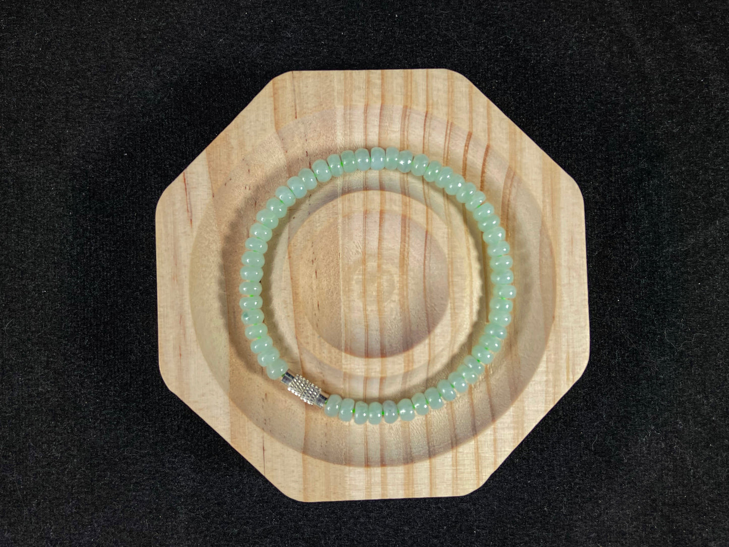 A strand of translucent light green oval jade beads.