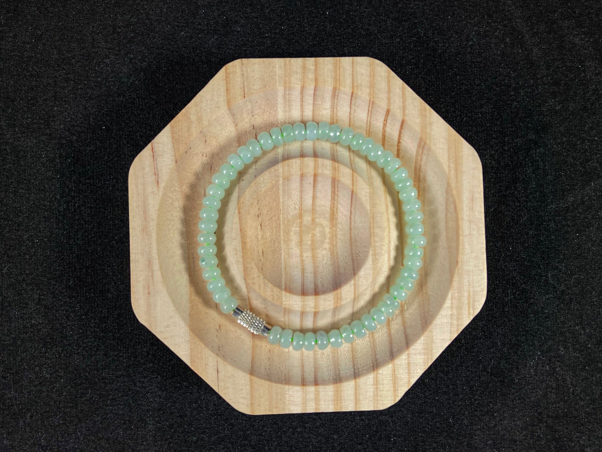 A strand of translucent light green oval jade beads.