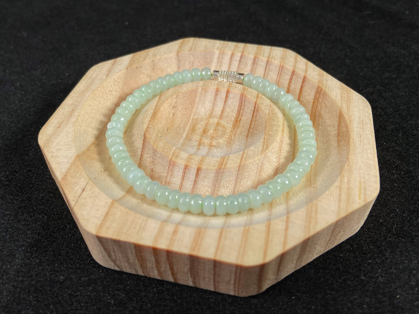 A strand of translucent light green oval jade beads.